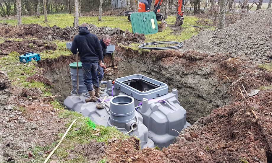 Deux employés installant une micro-station d'épuration