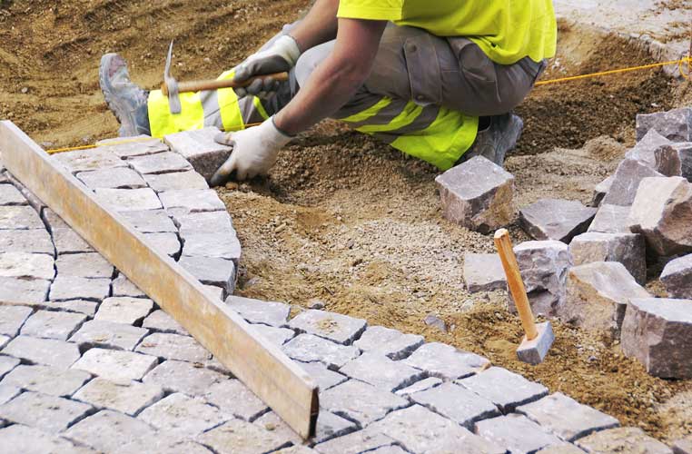 Ouvriers de MPTP qui installe des pavés en arc de cercle